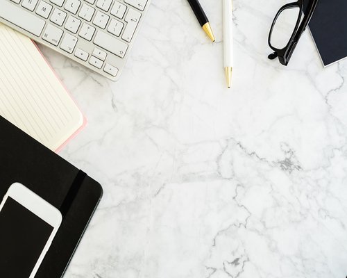A well-organized home office layout with a simple desk setup, structured schedule notebook and plant