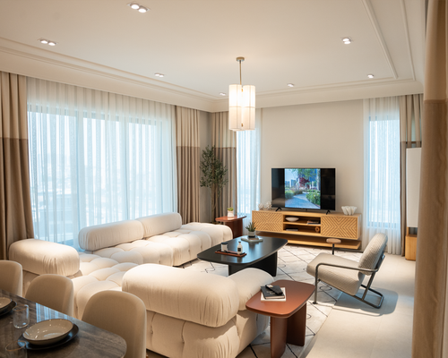 A modern apartment living room with ample light distribution and comfortable seating spaces